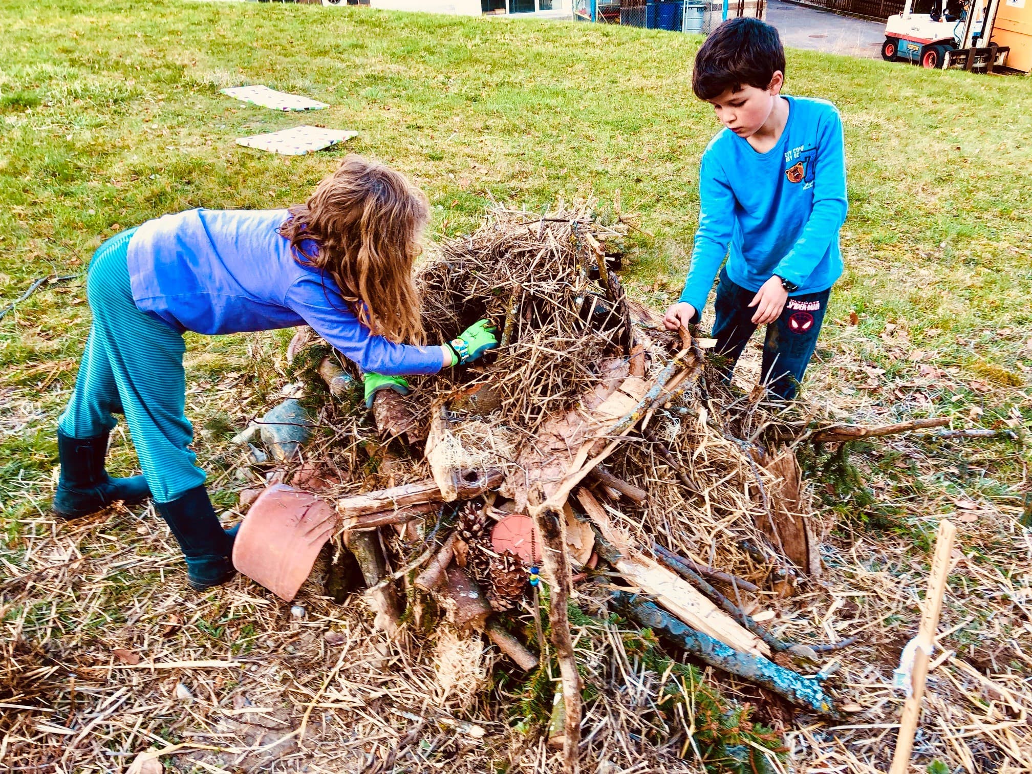 Die Schüler:innen helfen fleissig, einen Asthaufen zu bauen.
