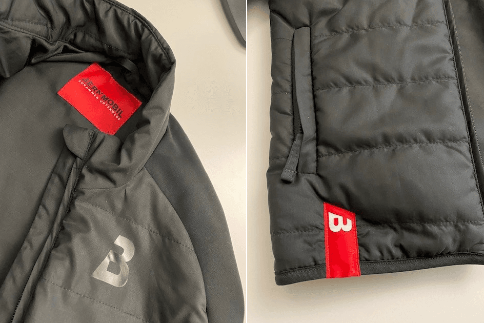 Nahansicht eines Jackenkragens und des Bunds mit dem Bernmobil-Logo.