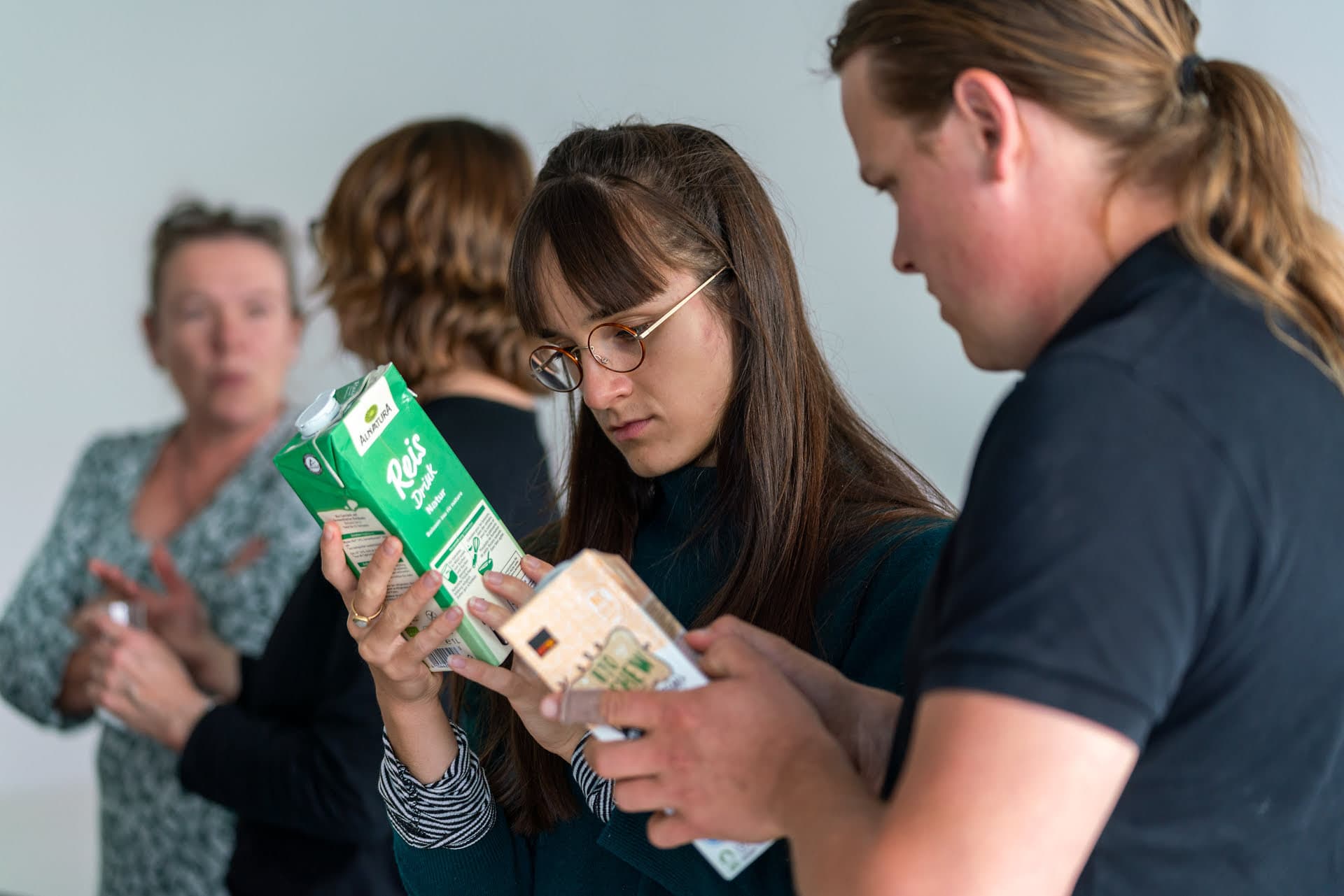 Mann und Frau begutachten zwei verschiedene Tetra Pak Milchalternativen