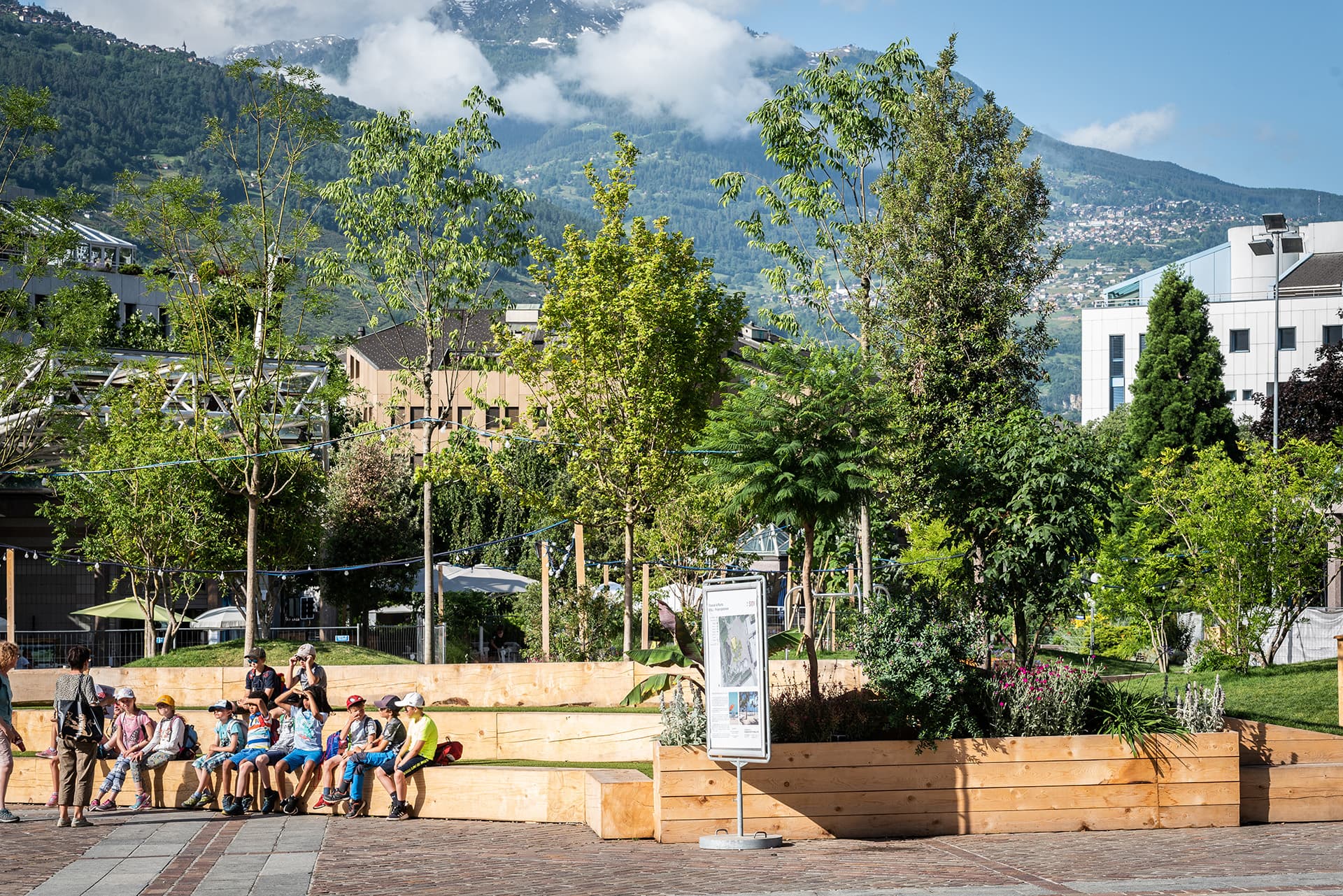 Espace végétalisé avec endroits en bois pour s'asseoir avec classe d'enfants