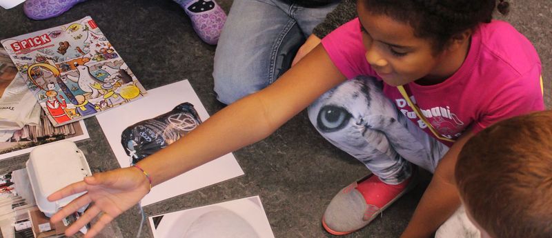 Das Titelbild des Pusch-Jahresberichts zeigt Kindergartenkinder, die am Boden sitzen und laminierte Fotos und Illustrationen zum Thema Abfall sortieren. 